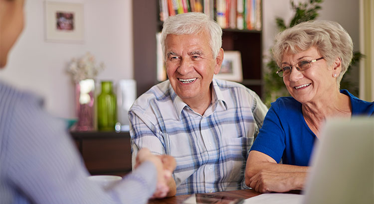 older couple shaking hands with realtor